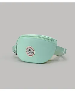 Macro detail of mint green canvas waist bag with star logo patch and zipper