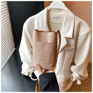 Dettaglio della mini borsa porta cellulare beige in pelle con trama a litchi