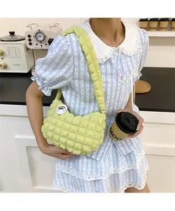 Gros plan du sac à bandoulière vert clair à texture popcorn avec badge arc-en-ciel