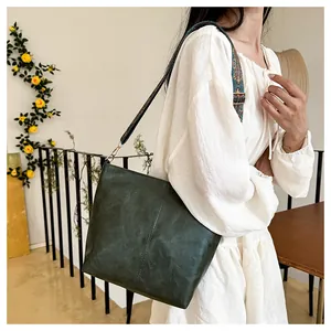 Detail of vintage green tote with wide ethnic jacquard strap and leather texture