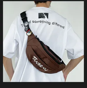 Detailed back view of a brown canvas crossbody bag with white logo and decorative badges