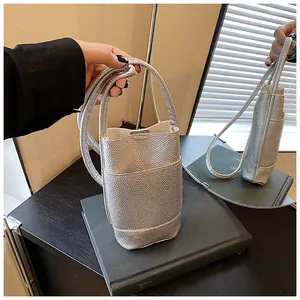 Dettaglio della borsa a secchiello argento con texture metallizzata a grana litchi