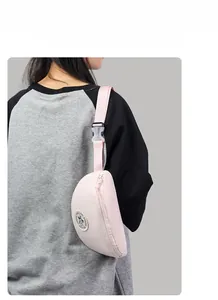 Detail of light pink crescent waist bag with adjustable strap and durable buckle