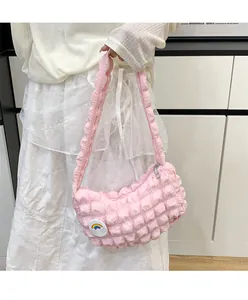 Détail du sac nuage plissé rose avec texture 3D et badge arc-en-ciel sur l'épaule