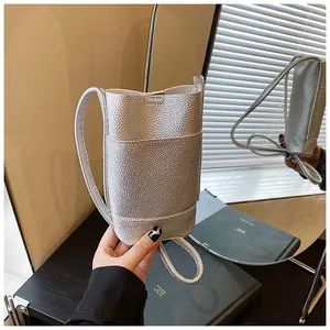 Vista dettagliata della mini borsa a tracolla argento in pelle martellata con riflesso