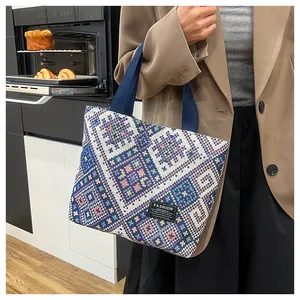 Close-up of geometric woven pattern and canvas handles on a large ethnic tote bag