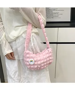 Gros plan du sac nuage rose avec texture matelassée et broche nuage arc-en-ciel