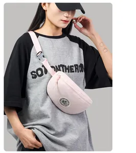 Detail of light pink canvas fanny pack with round logo and white plastic buckle on strap