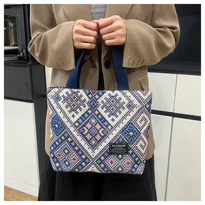 Detailed texture of geometric ethnic woven tote bag featuring blue and pink diamond patterns