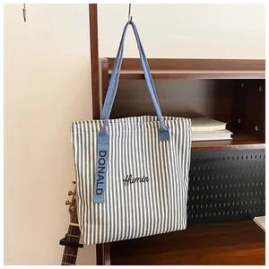 Detailed embroidery and striped canvas fabric on a large capacity tote bag