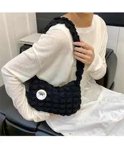 Détail du sac à bandoulière noir matelassé avec un joli badge de nuage arc-en-ciel