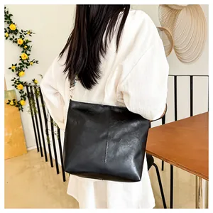 Detail of black faux leather hobo bag with vintage geometric printed wide shoulder strap