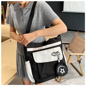 Détail du sac bandoulière imperméable en toile avec motif étoile et texte de mode