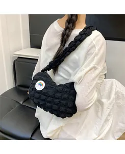 Détail du sac bandoulière noir à bulles avec badge nuage arc-en-ciel sur modèle