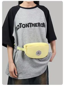 Detail view of a pale yellow fanny pack with a star logo patch and nylon adjustable strap