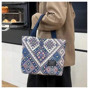 Detail of ethnic geometric woven tote bag with sturdy navy handle and fashion label