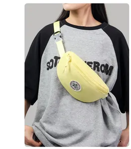 Detail of light yellow nylon waist bag with adjustable strap and circular star logo patch