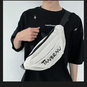 Detail of off-white canvas chest bag featuring black TANBRNU text and adjustable strap