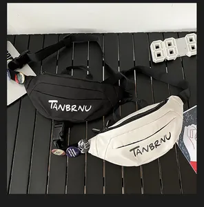 Detail view of black and white chest bags featuring letter print and decorative badges