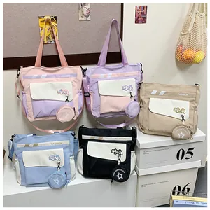 Détail du sac cabas en nylon bicolore avec poche frontale et pendentif en étoile