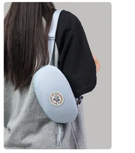 Detail view of light blue nylon crescent bag with adjustable strap and star patch logo