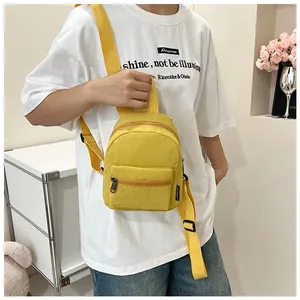 Dettaglio di un mini zaino in nylon giallo brillante impermeabile su una modella