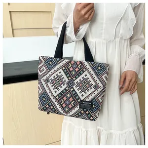 Detail of bohemian tote bag with colorful geometric patterns and fashion logo label