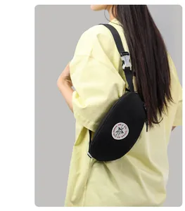 Side view of black nylon crossbody bag with adjustable strap and brand patch on model
