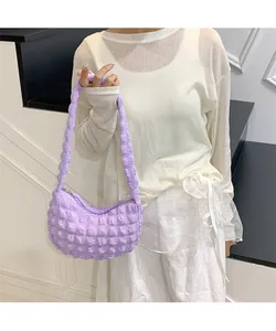 Texture détaillée d'un sac à bandoulière violet clair à bulles porté par un mannequin