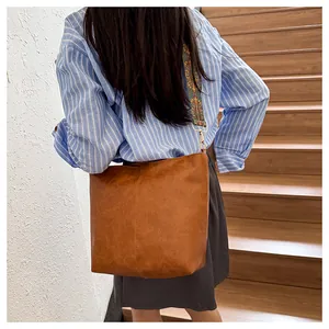 Detail of vintage brown tote bag featuring a colorful ethnic style woven wide strap