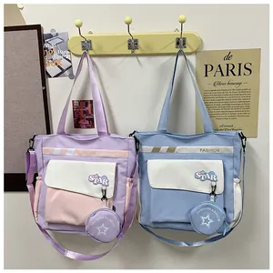 Détail de cabas en toile bicolores avec écussons étoiles et bandoulières réglables