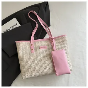 Close-up of woven tote bag with pink leather handles and matching small zipper pouch