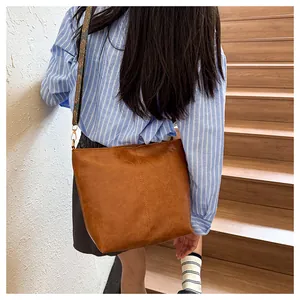Detail of vintage brown leather tote bag with ethnic pattern wide shoulder strap