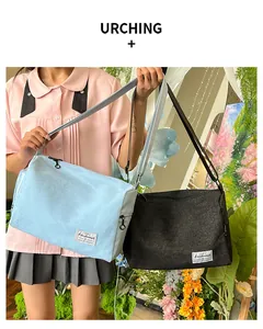 Adjustable canvas shoulder bag with external zipper pocket and branded label detail