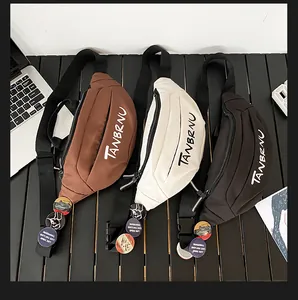 Three nylon crossbody bags in brown, white and black with pins on adjustable straps