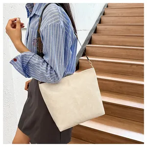 Detail of vintage beige tote bag featuring ethnic style embroidered wide shoulder strap