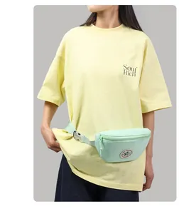 Close-up of mint green casual waist bag with circular logo and adjustable strap