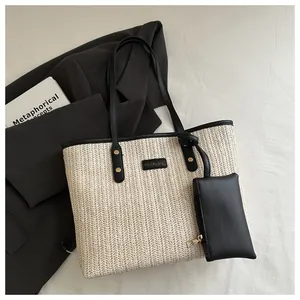 Detailed top view of large straw tote bag with black leather straps and mini pouch