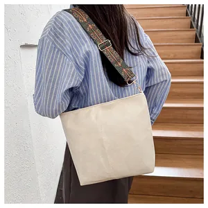 Detail of vintage beige tote bag featuring ethnic pattern wide strap and matte leather texture