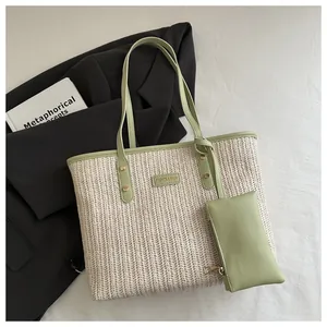 Close-up of woven straw tote bag with mint green leather trim and small matching pouch
