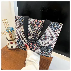 Detailed shot of ethnic woven tote bag with colorful geometric patterns and fabric handles