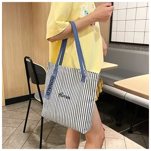 Detail of blue and white striped canvas tote bag with Donald tag and floral embroidery