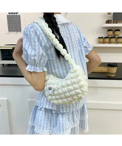 Gros plan du sac bandoulière blanc plissé avec badge arc-en-ciel sur l'épaule