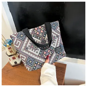 Close-up of geometric woven tote bag with ethnic patterns and fashion instinct label