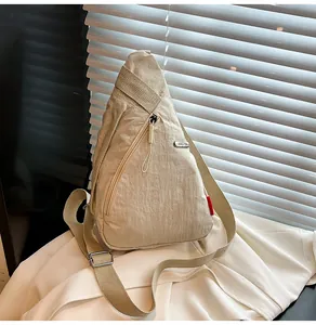 Λεπτομερής όψη μπεζ τσάντας χιαστί με ρυθμιζόμενο λουράκι και υφή από τσαλακωμένο ύφασμα
