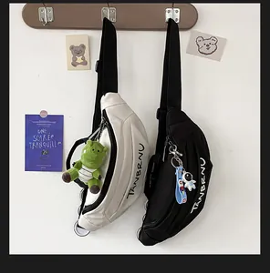 Detail of durable canvas chest bags in beige and black with cute dinosaur and astronaut charms