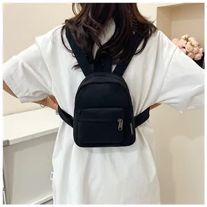 Mini zaino nero in nylon indossato dal modello che mostra dimensioni e cinghie