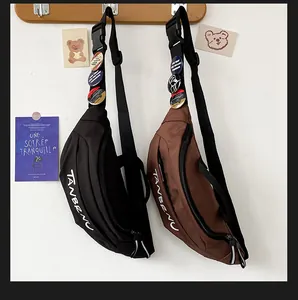 Detail view of black and brown canvas crossbody bags with adjustable straps and badges