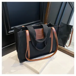 Detail view of canvas tote bag with brown leather accents and Fashion Bag text print