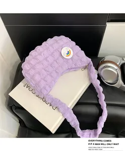 Détail du tissu froncé mauve du sac nuage avec épingle arc-en-ciel sur un livre
